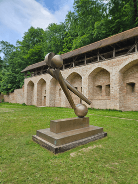 The artwork stands on a green space