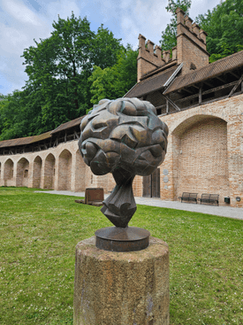 The artwork stands on a green space