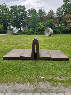 The artwork stands on a green space