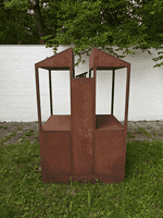 Das Kunstwerk aus Eisen steht auf einer Grünfläche vor dem Hof von Fritz und Maria Koenig
