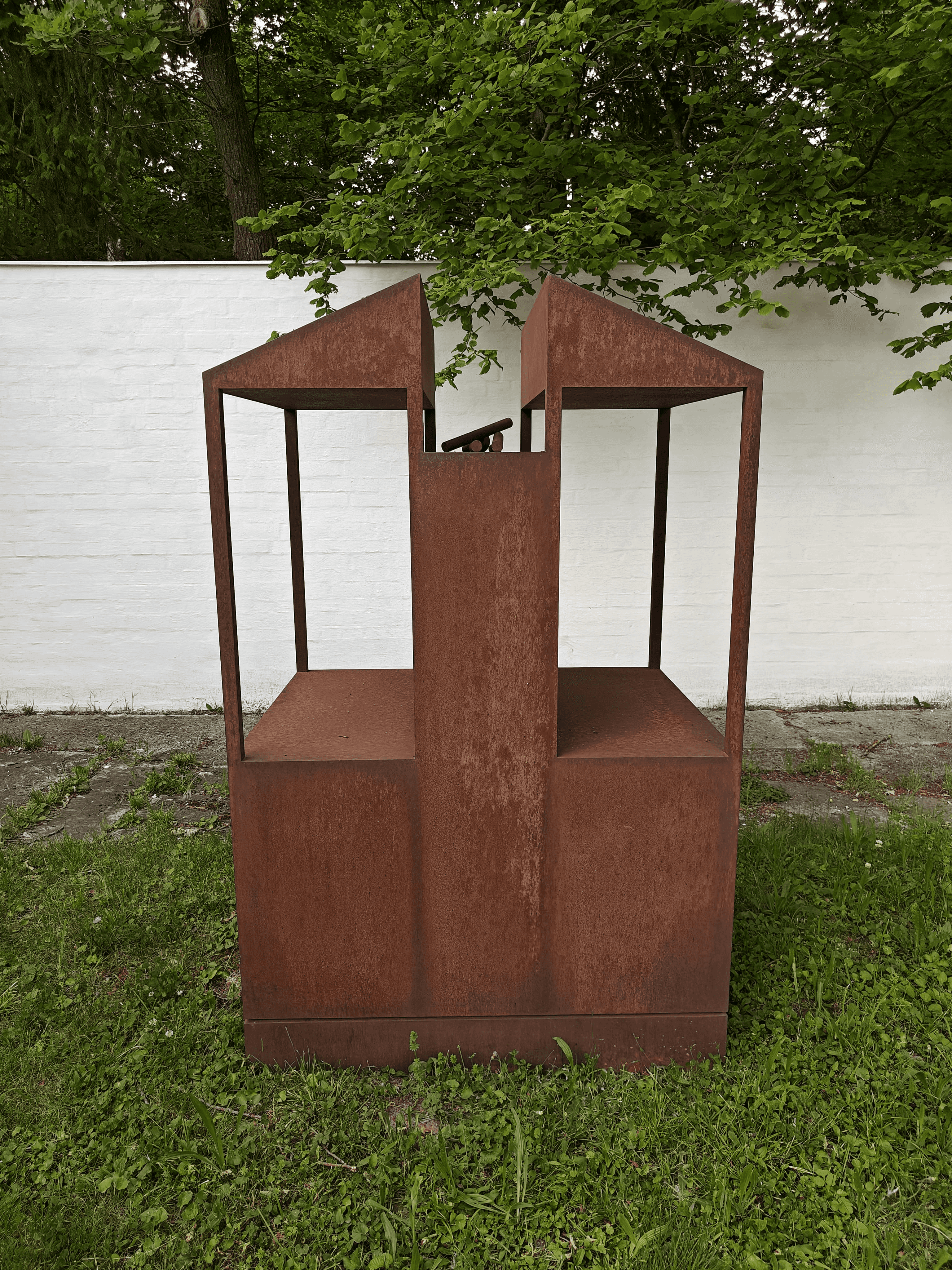 Das Kunstwerk aus Eisen steht auf einer Grünfläche vor dem Hof von Fritz und Maria Koenig