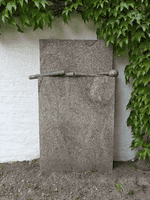 Das Kunstwerk aus Granit steht vor einer Mauer des Vierseithofs von Fritz und Maria Koenig