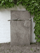 Das Kunstwerk aus Granit steht vor einer Mauer des Vierseithofs von Fritz und Maria Koenig