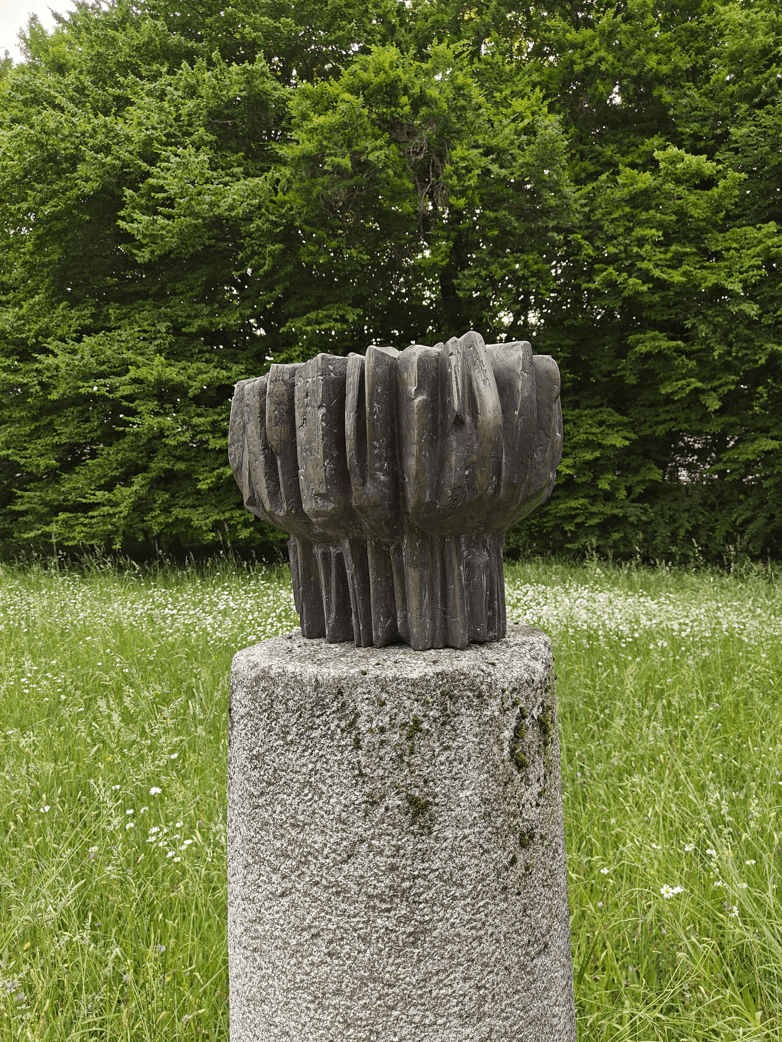 Das Kunstwerk aus Bronze steht auf der Grünfläche 