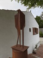 Das Kunstwerk aus Eisen steht auf einer Grünfläche bei dem Hof von Fritz und Maria Koenig
