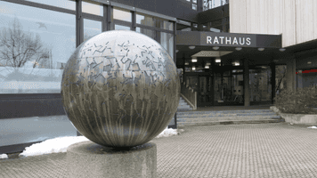 Das kugelförmige Kunstwerk aus Bronze steht vor dem Rathaus der Gemeinde Unterföhring