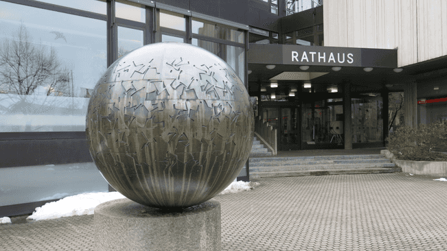 Das kugelförmige Kunstwerk aus Bronze steht vor dem Rathaus der Gemeinde Unterföhring